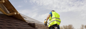 Man working on roof installing shingles